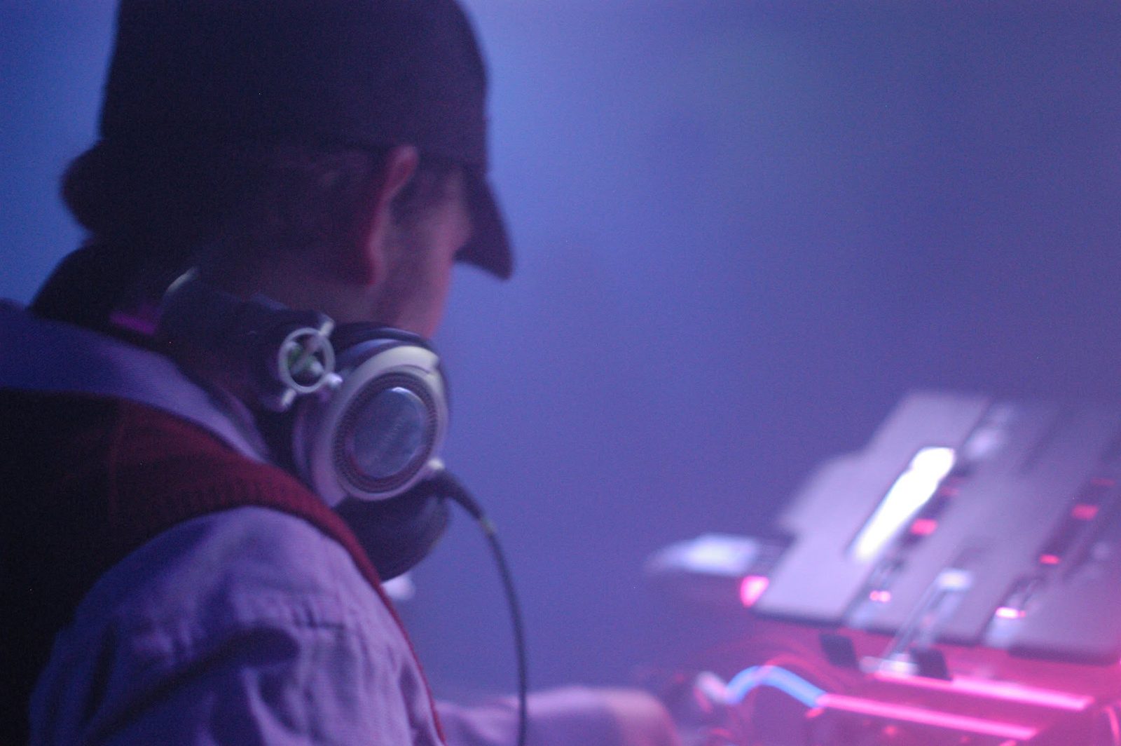 Unkle Funk behind the decks, lit in violet haze